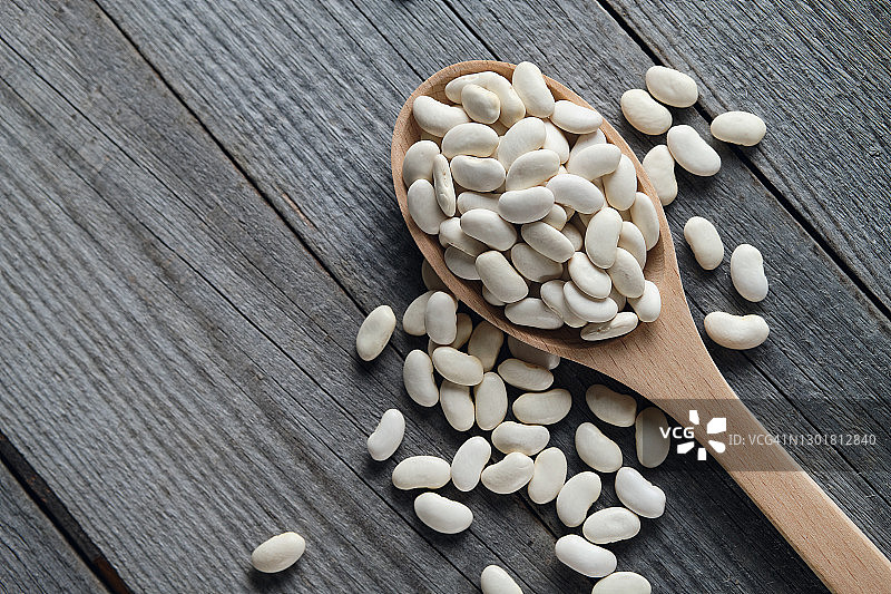 木勺中的干燥白豆，桌面背景，素食和纯素食品，植物蛋白图片素材