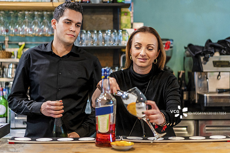 女调酒师与男助理调制鸡尾酒图片素材