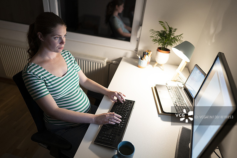 在家工作到很晚的孕妇图片素材