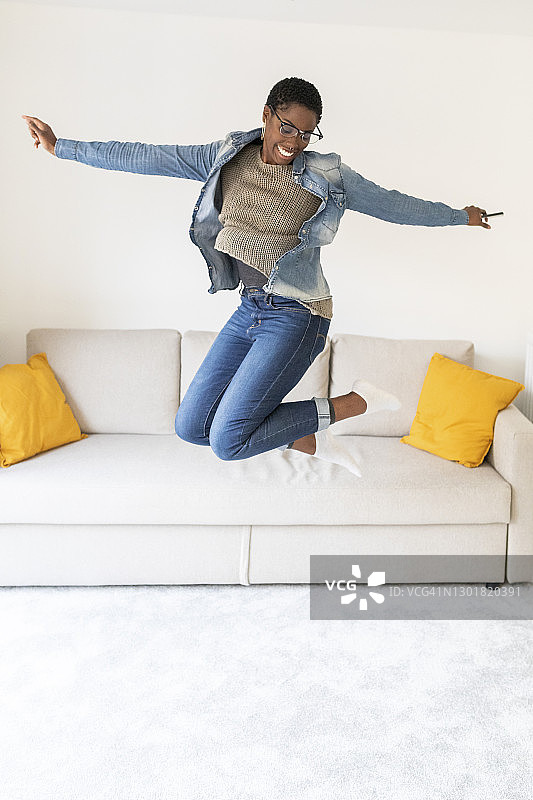 女人在沙发前跳跃图片素材