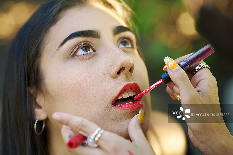 女人给另一个女人涂口红图片素材