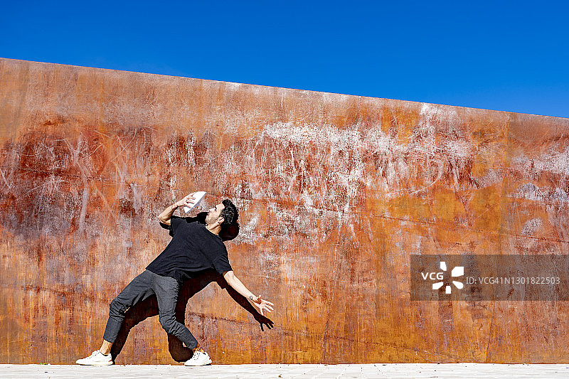 男人靠墙站着，看着口罩图片素材