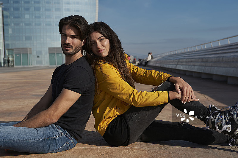 在阳光明媚的日子里坐在码头上的异性恋夫妇图片素材