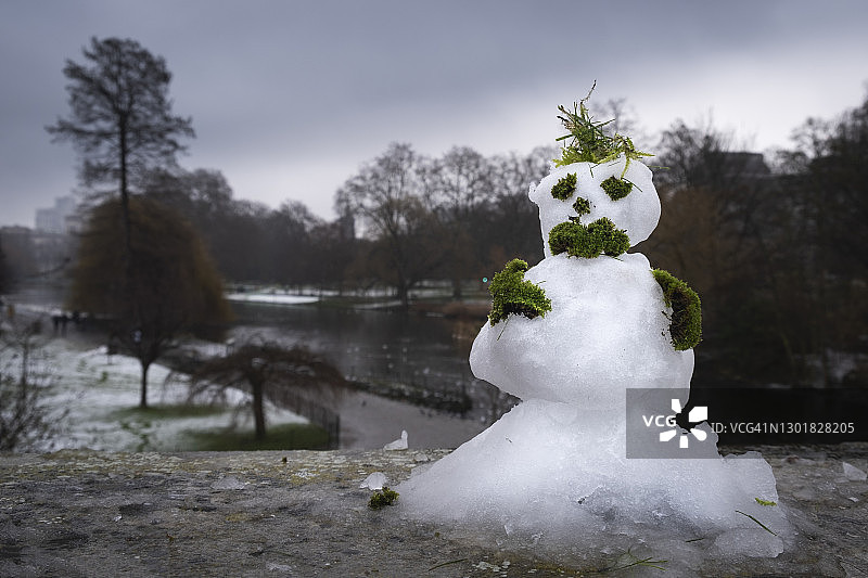 建在墙上、以城市公园为背景的雪人图片素材