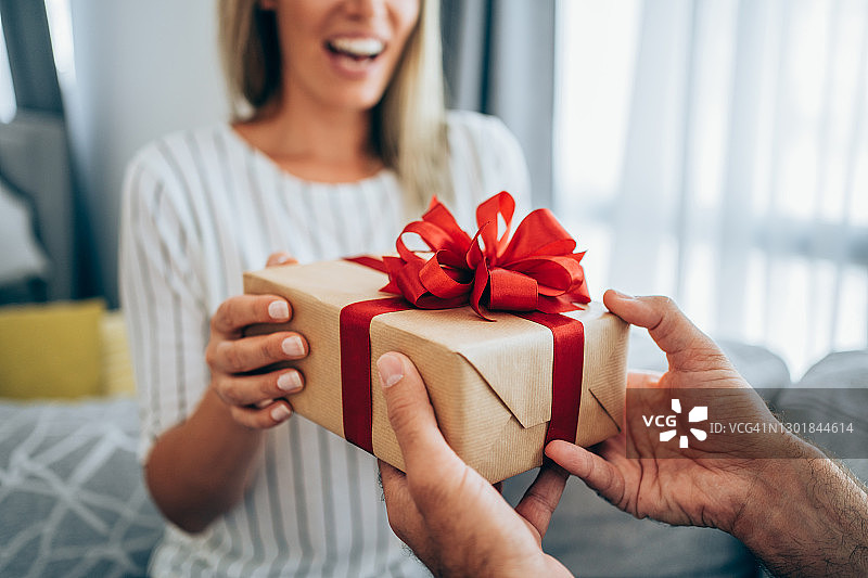 快乐的年轻女人收到男友的礼物图片素材