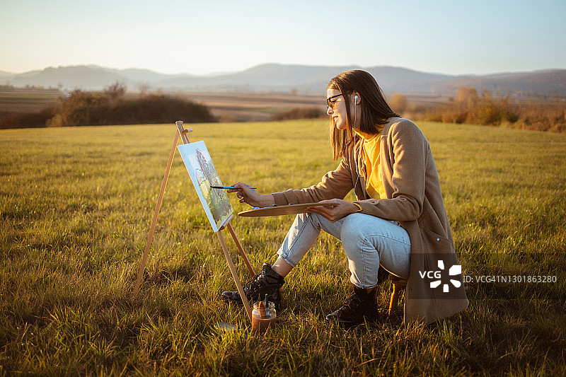年轻女子在户外写生图片素材