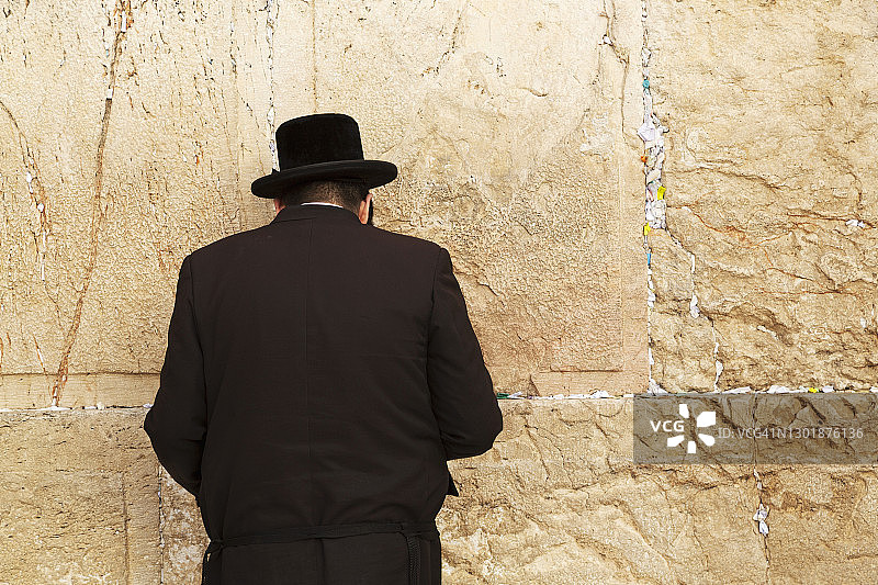 一名身穿正统服装的犹太教男人在以色列耶路撒冷西墙（哭墙）旁祈祷图片素材