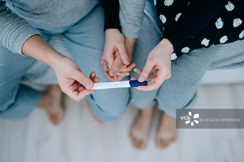 俯视视角：年轻亚洲夫妇庆祝怀孕图片素材