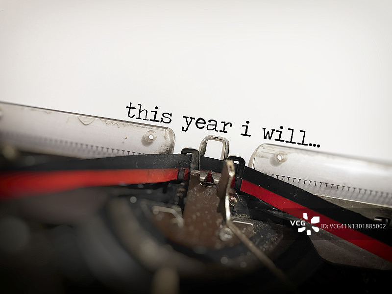 在半散景经典复古打字机上键入的“今年我将”。新年概念和白色背景图片素材