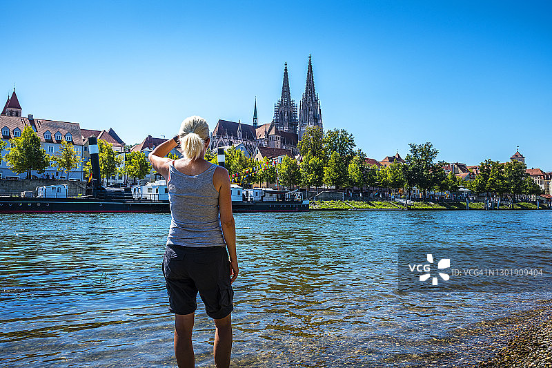 从雷根斯堡和多瑙河看大教堂的女人图片素材