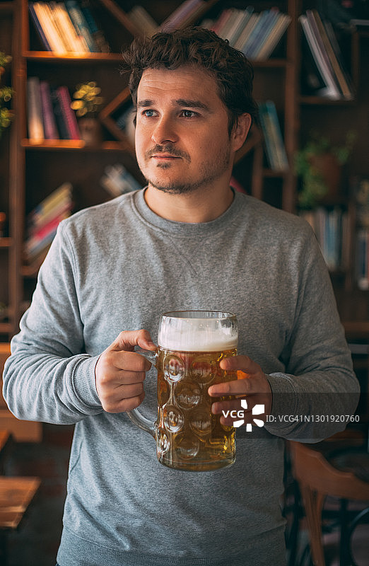 在酒吧喝啤酒的英俊男人图片素材
