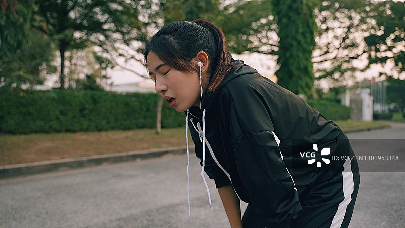 在泰国曼谷跑步、伸展和听音乐的亚洲女运动员图片素材
