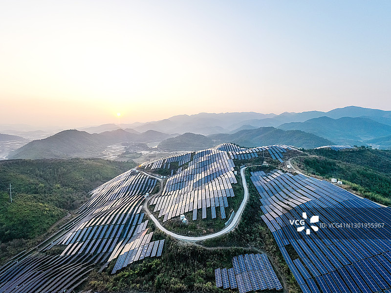 与山间植物和谐共生的太阳能发电厂鸟瞰图片素材