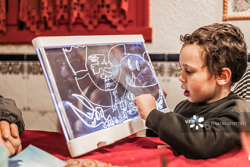 在家用画板玩具画画的小男孩图片素材