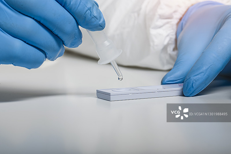 医务人员进行新冠抗原快速检测拭子样本滴取的细节图片素材