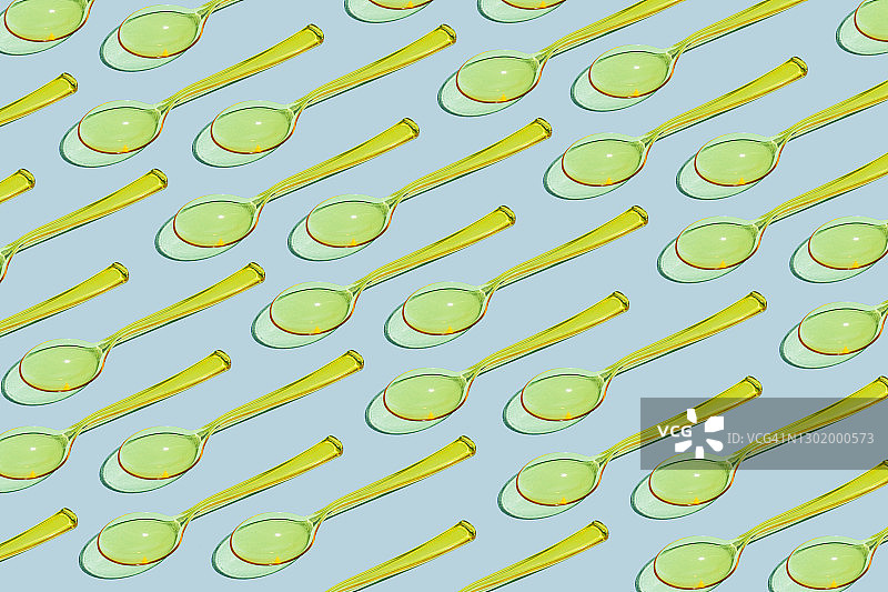 淡蓝色背景上的黄色一次性塑料勺。塑料回收和生态概念。平铺，俯视图图片素材