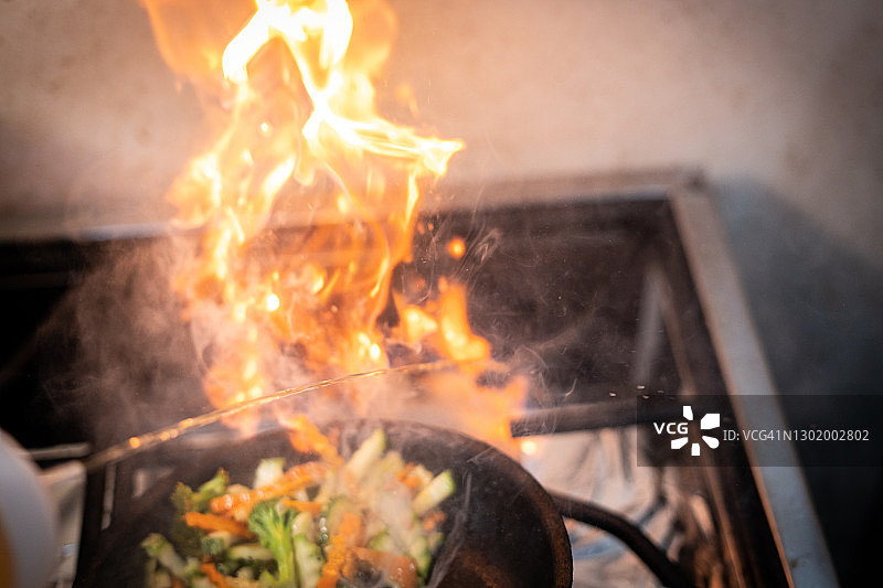 餐厅炉灶上用平底锅烹制的火焰美食，哥斯达黎加美食图片素材