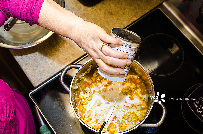 女人在平底锅里倒椰奶图片素材