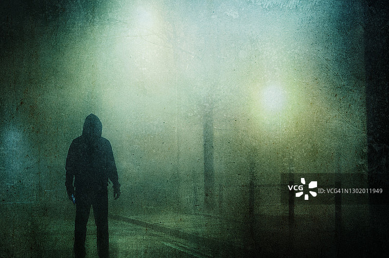 雾冬之夜街上的抽象连帽人像图片素材