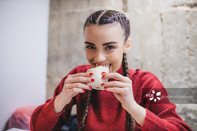 快乐的女人吃鸡肉卷图片素材