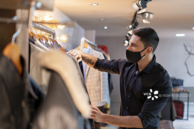 年轻男人在仓库整理衣服图片素材