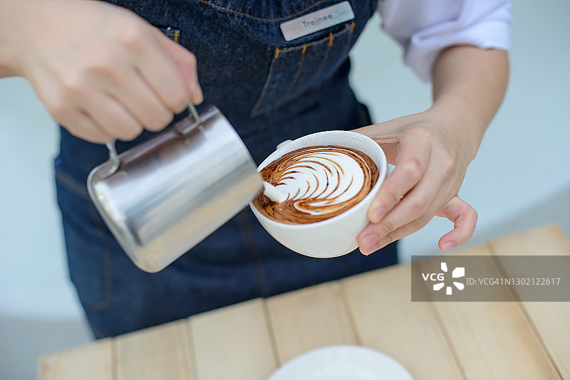咖啡师将蒸汽牛奶倒入咖啡图片素材