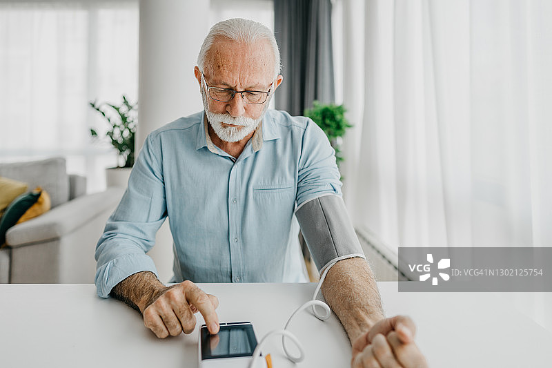年长的男人检查他的血压图片素材