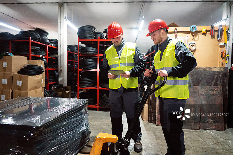 男工人在仓库里整理健身房橡胶垫图片素材