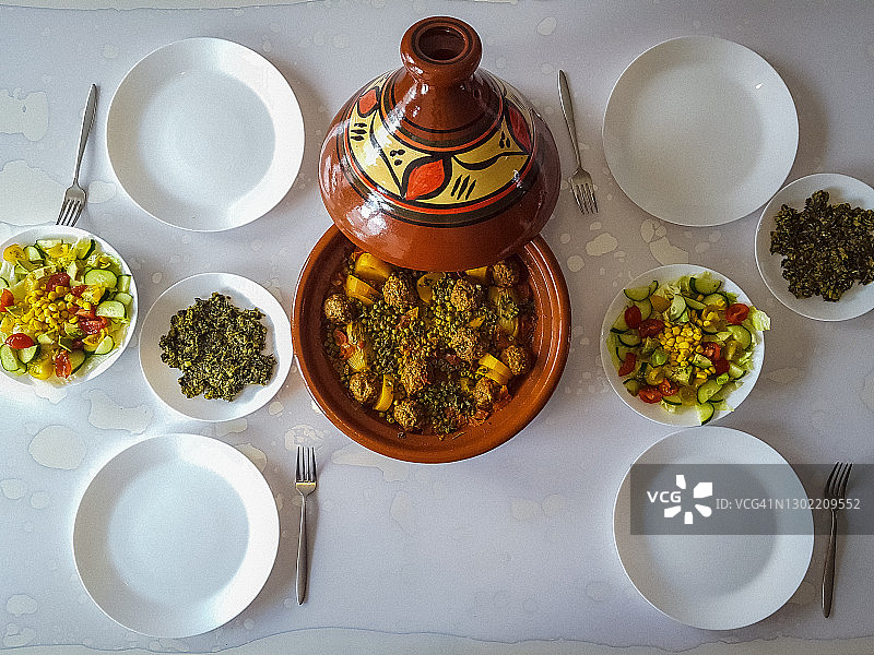桌上美食高角度视图（豌豆土豆肉丸、沙拉和菠菜塔吉锅）图片素材