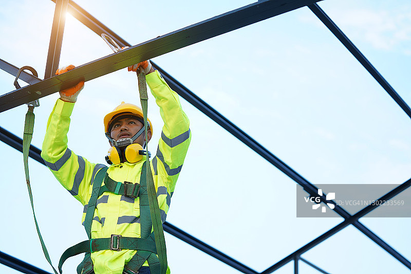 工人在新屋顶上安装金属板，屋面工具图片素材