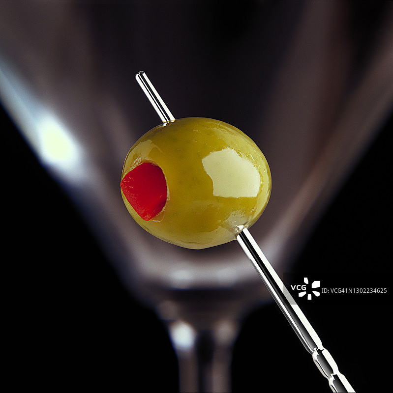银色鸡尾酒棒上的酿橄榄特写图片素材