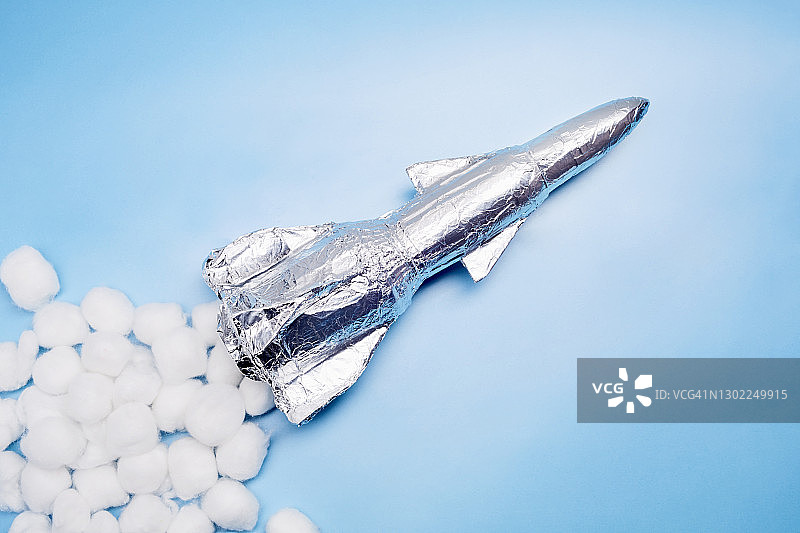 自制火箭与白色棉球静物摄影，蓝色背景图片素材