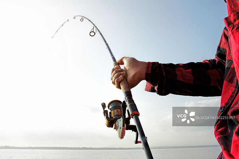 渔民在湖中用钓竿钓鱼图片素材