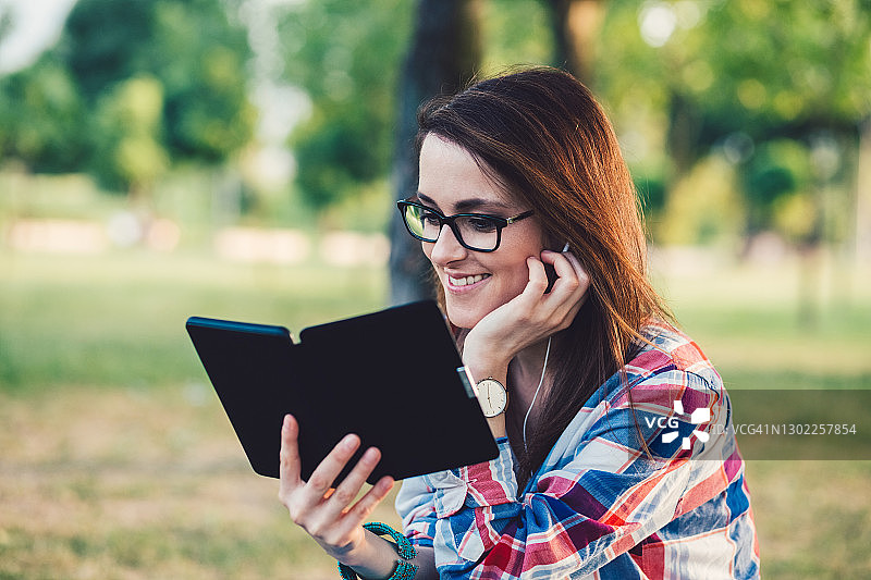 在自然中阅读电子书的女人图片素材