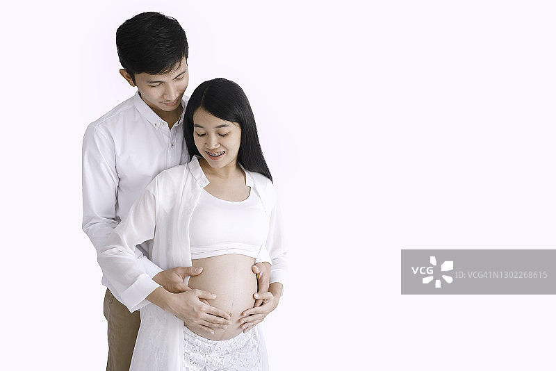 怀孕的夫妻幸福地拥抱在一起图片素材