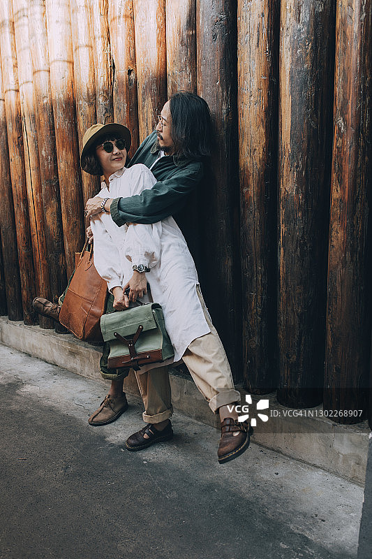 快乐的泰国夫妇站在街上拥抱图片素材