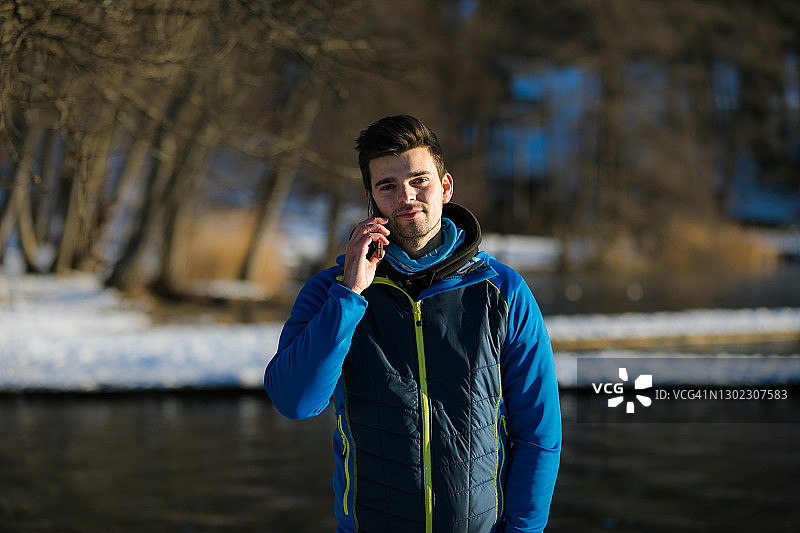 冬天使用手机的年轻白人男子图片素材