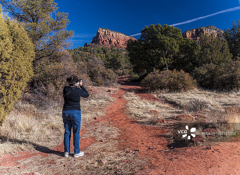 成年妇女在亚利桑那州塞多纳拍摄红色岩石地貌图片素材