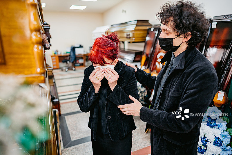 儿子在殡仪馆安慰母亲图片素材