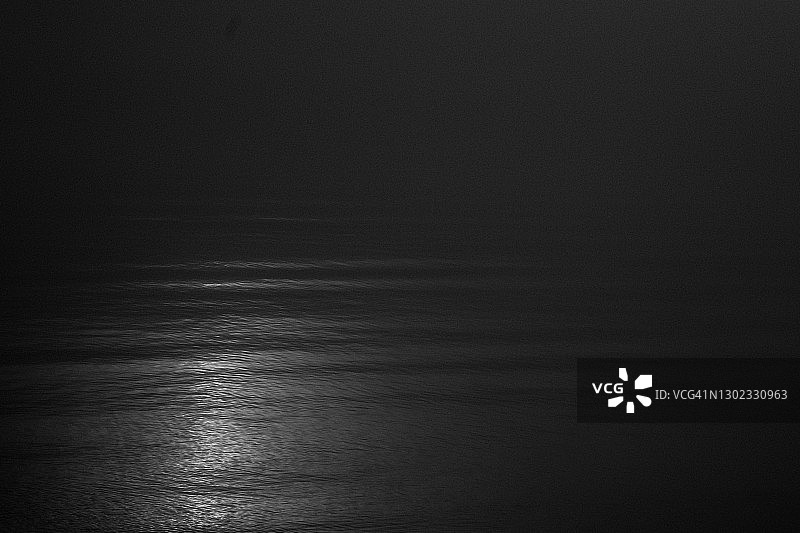 平静水面上光线反射的黑白抽象图像图片素材