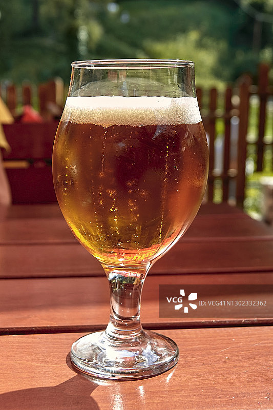 户外桌上的一杯冰镇精酿啤酒图片素材