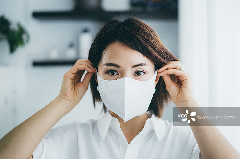 戴防护口罩的亚洲年轻女性肖像，预防冠状病毒图片素材