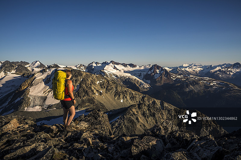 在崎岖地形中徒步旅行的背包女人图片素材