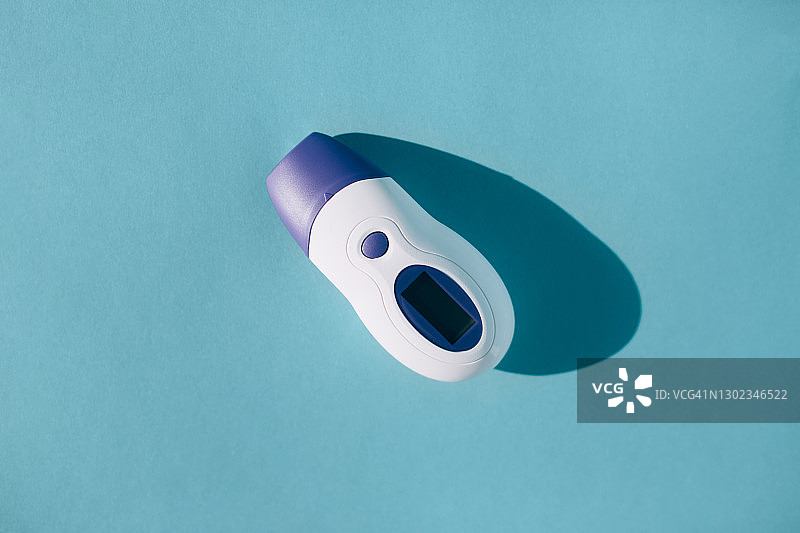 蓝色背景上的电子温度计图片素材