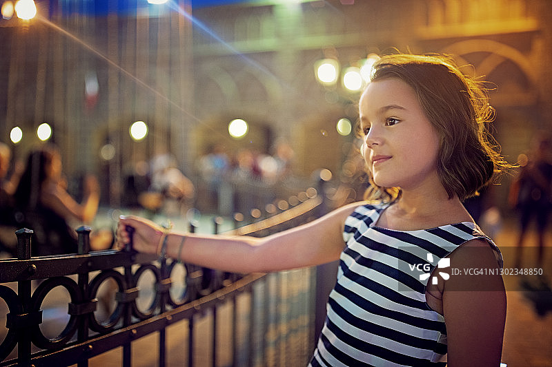 快乐的女孩在游乐园里等待旋转木马图片素材