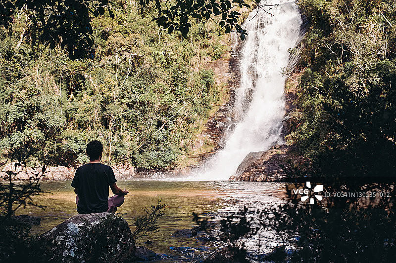 男人在瀑布旁冥想图片素材