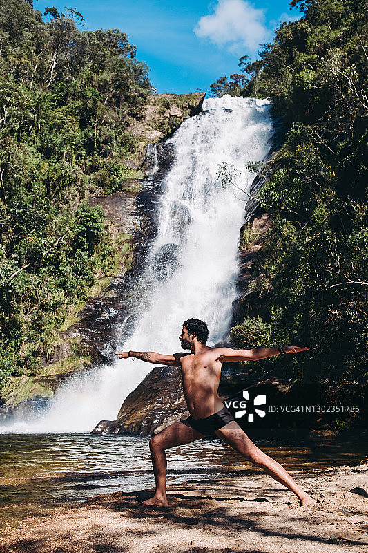 在瀑布前做瑜伽的男人图片素材
