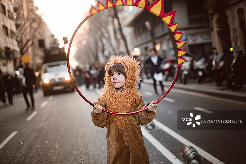 男孩打扮成狮子在街上表演图片素材