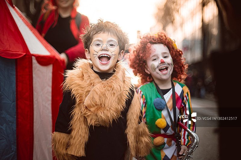 男孩扮成狮子和扮成小丑的男孩一起唱歌图片素材