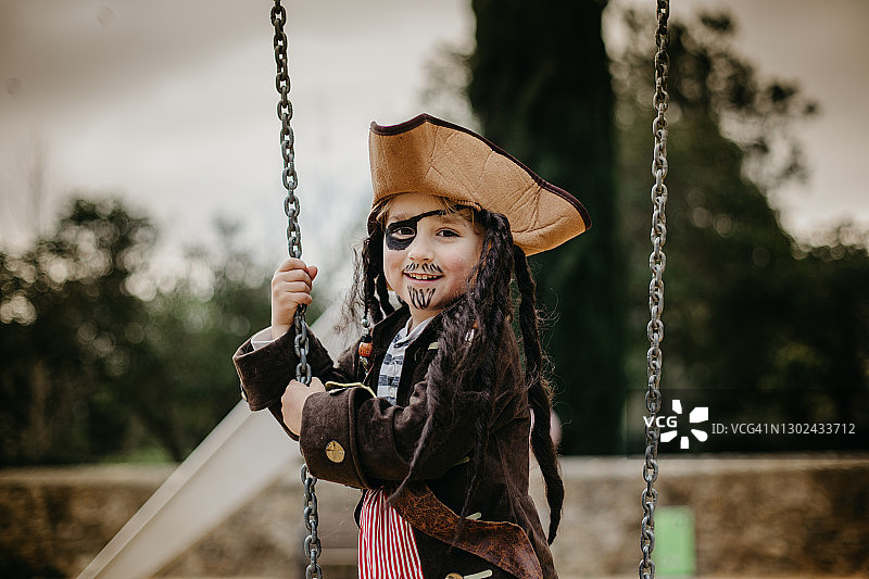 装扮成海盗的男孩在秋千上看着镜头图片素材